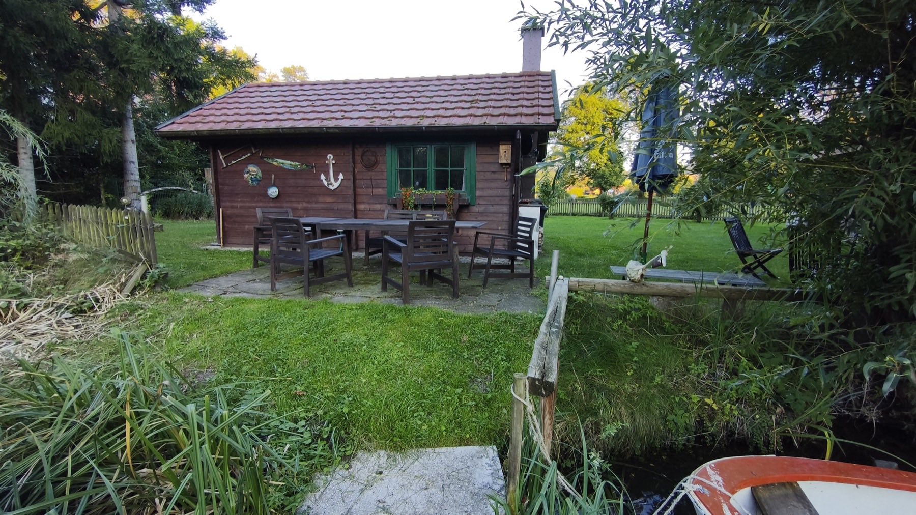 Hütte am Teichufer mit Sitzgruppe und Boot